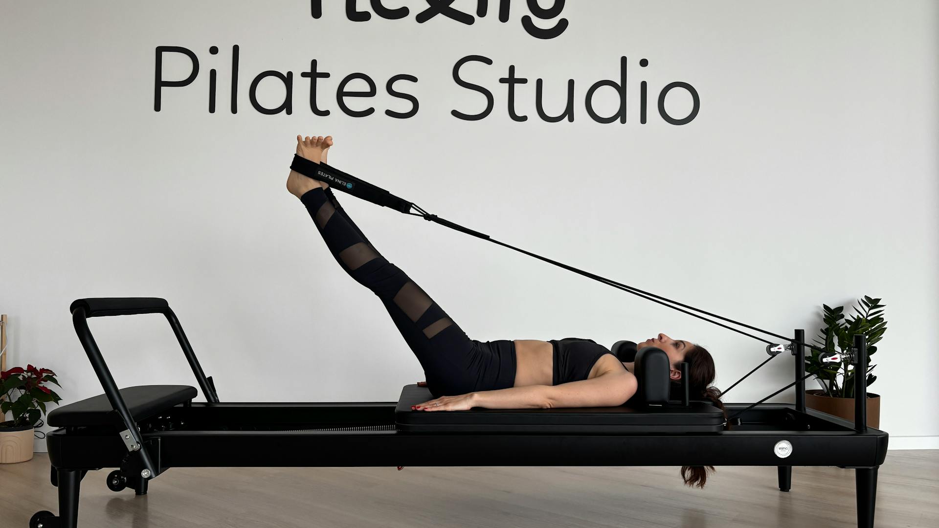Woman exercising on Pilates reformer in a studio